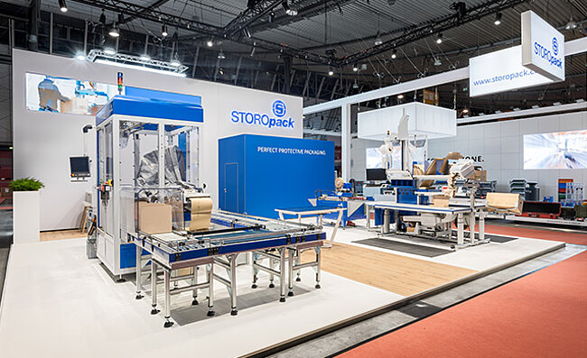 A Storopack trade fair stand with four blue display cases